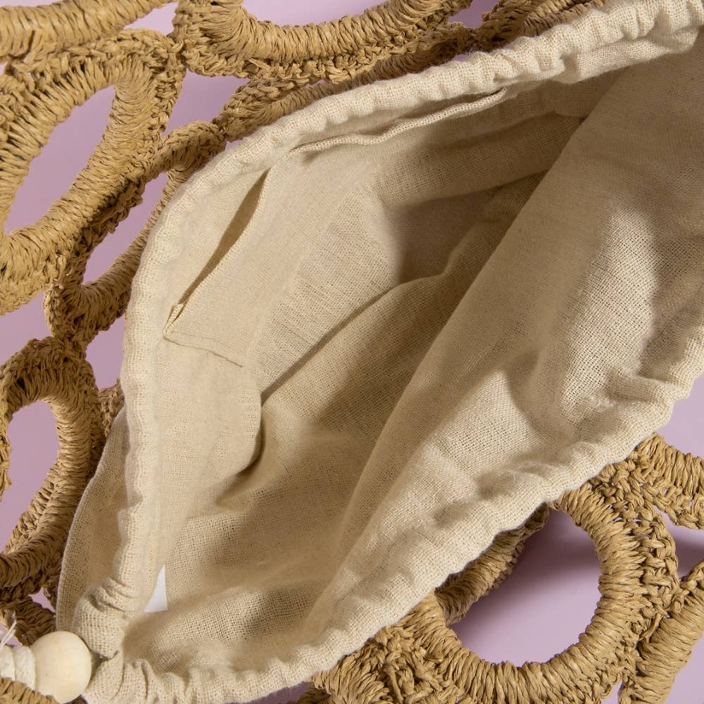 Beige fabric draped over woven circular objects on a pink background