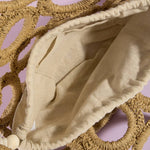 Beige fabric draped over woven circular objects on a pink background