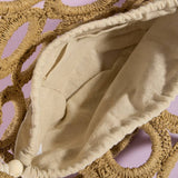 Beige fabric draped over woven circular objects on a pink background