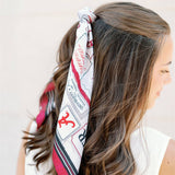 Woman wearing a patterned headscarf with a plain background